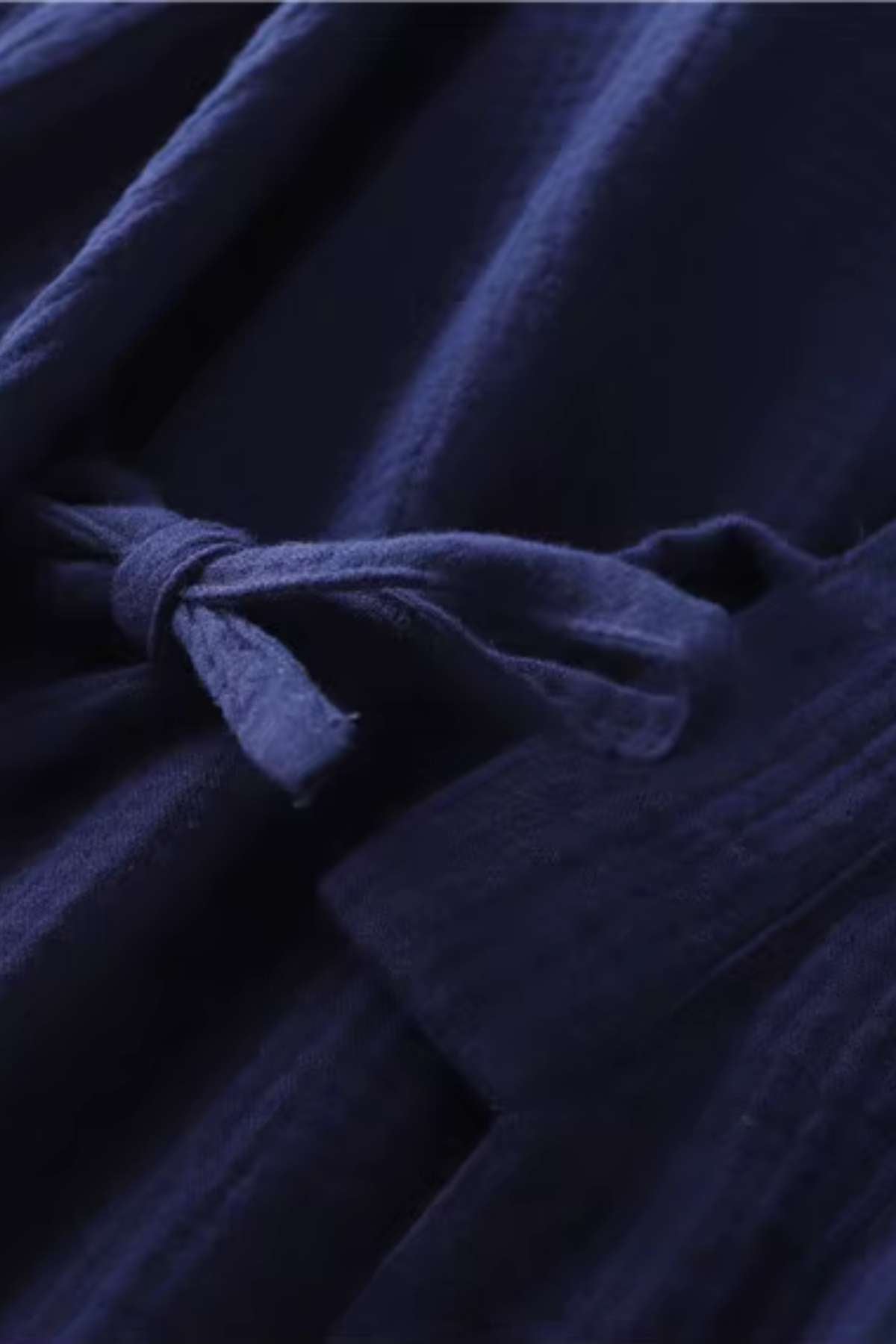 Tissu en coton bleu foncé avec un nœud délicat, évoquant un style japonais et une atmosphère de sérénité