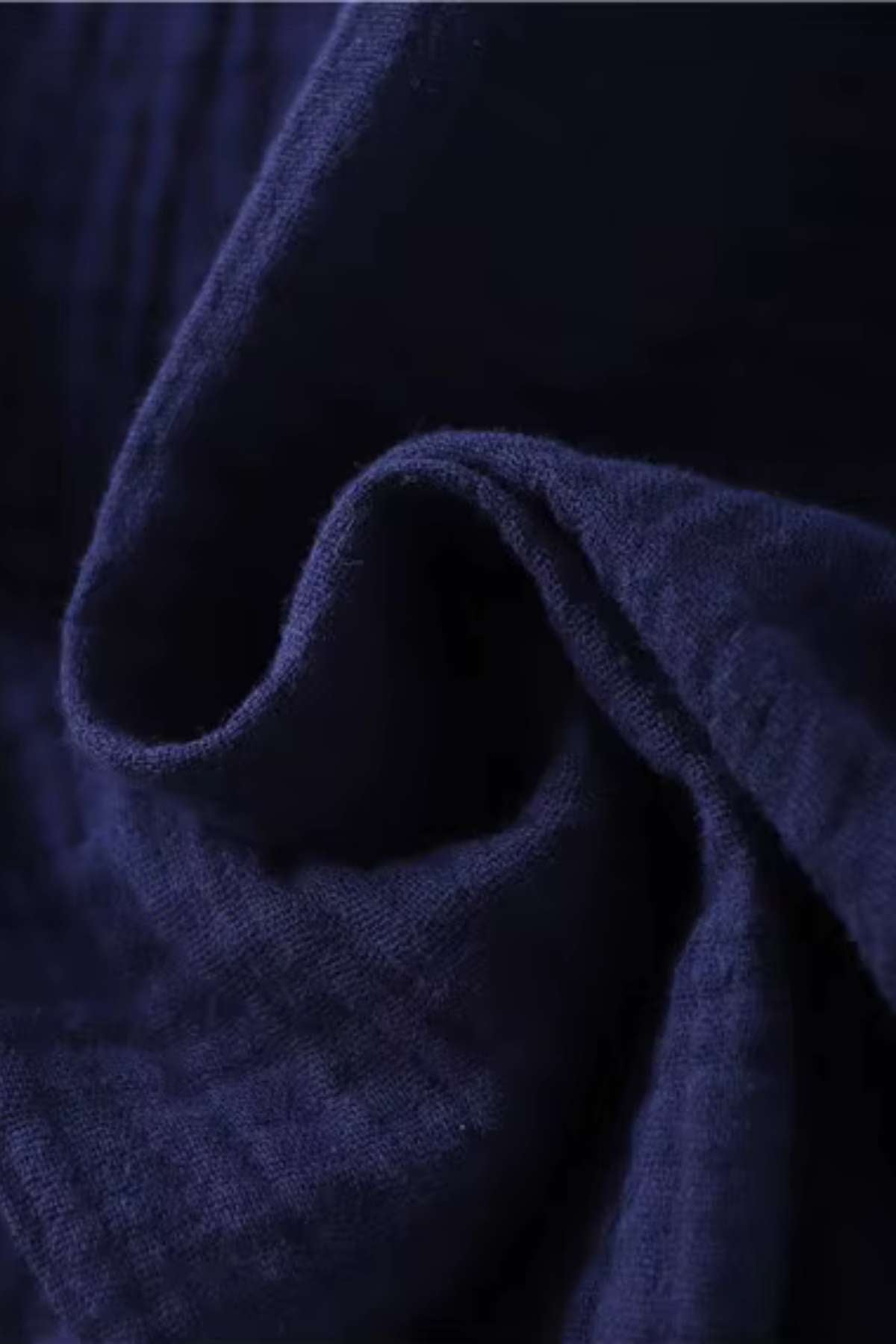 Tissu en coton de couleur bleu nuit, légèrement froissé, avec une texture douce et légère, évoquant la sérénité