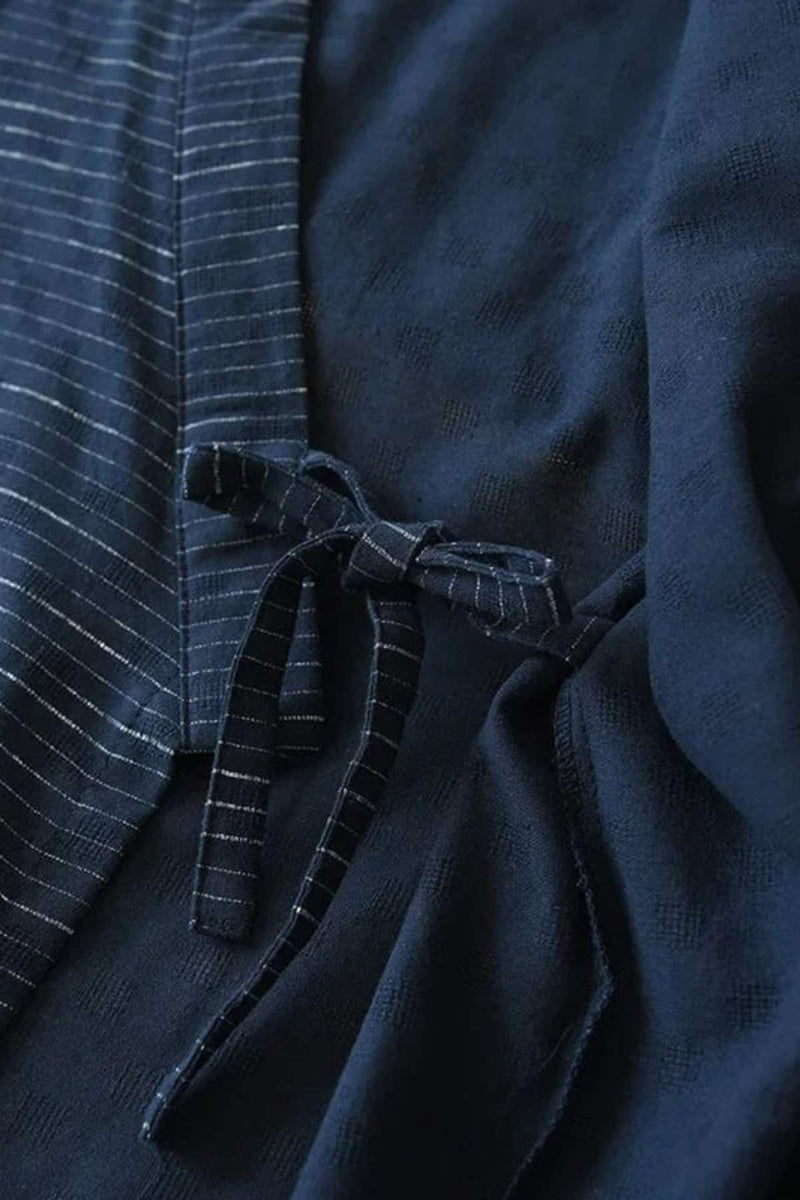 Détail d'un kimono pyjama homme en tissu bleu marine avec motifs rayés et un nœud élégant
