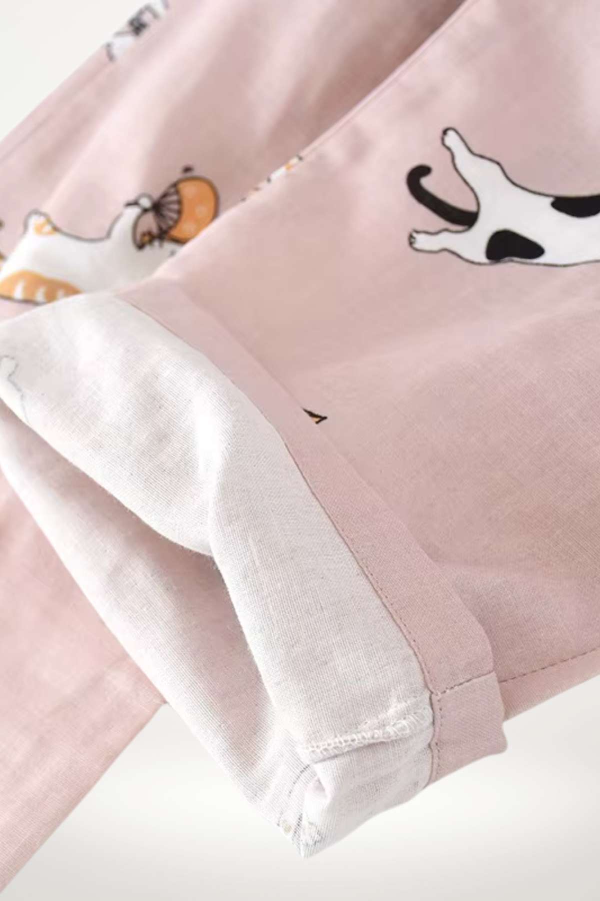 Un kimono pyjama léger en tissu rose avec des motifs d'animaux et des manches blanches