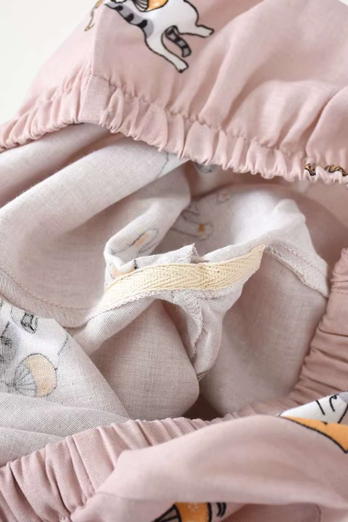 Tissu léger de couleur rose avec motifs d'animaux, présentant des finitions élastiques et douces au toucher