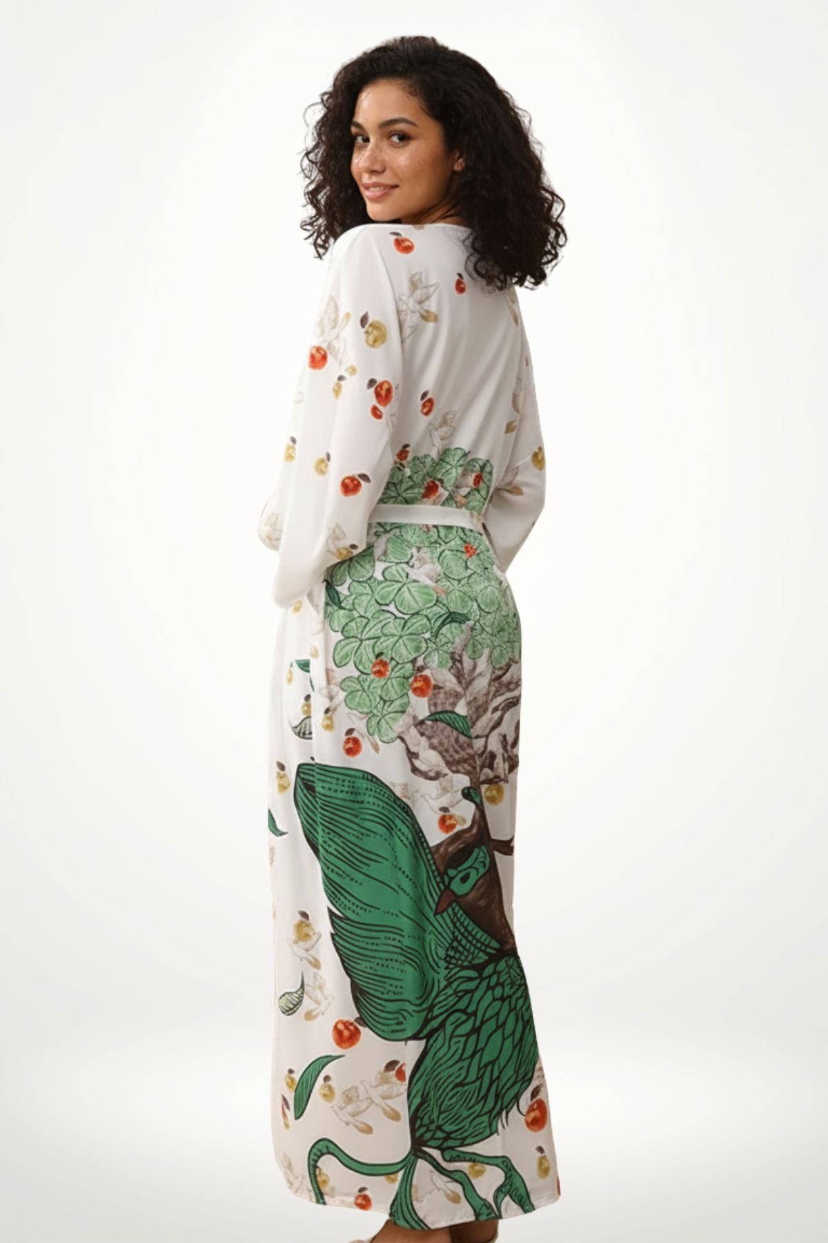 femme portant un Kimono en satin blanc avec motifs verts de paon et fruits, dans un décor lumineux