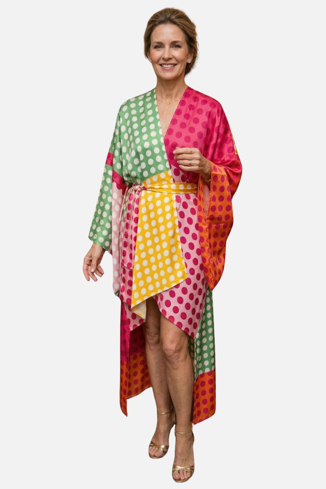 Femme souriante portant un kimono en satin coloré à pois, avec des teintes vertes, roses, jaunes et oranges