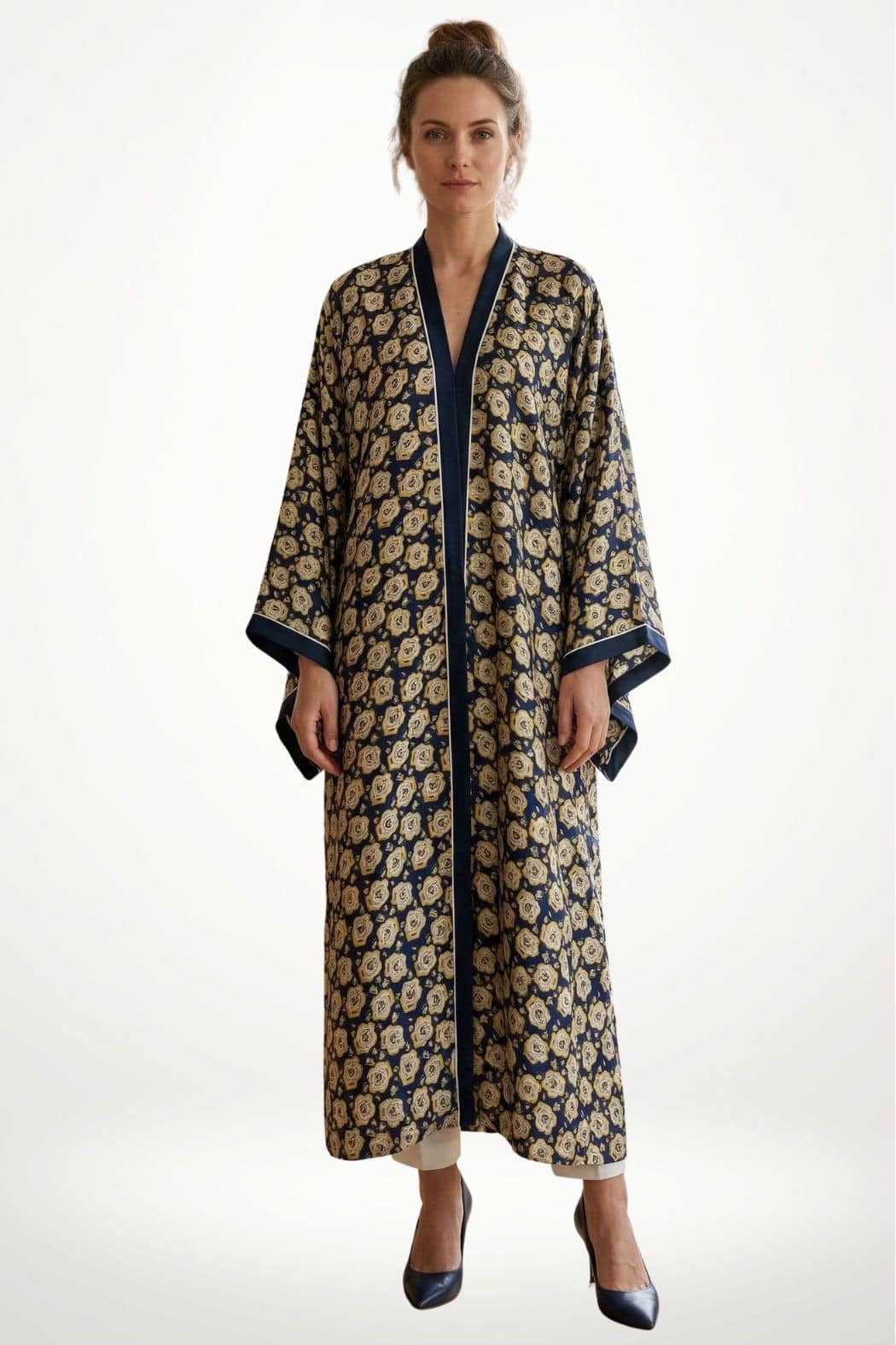 Femme portant un kimono en satin bleu marine à motifs floraux dorés, dans une posture élégante sur fond blanc