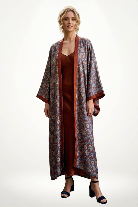 Femme portant un kimono en satin aux motifs floraux, avec une robe marron et des sandales noires