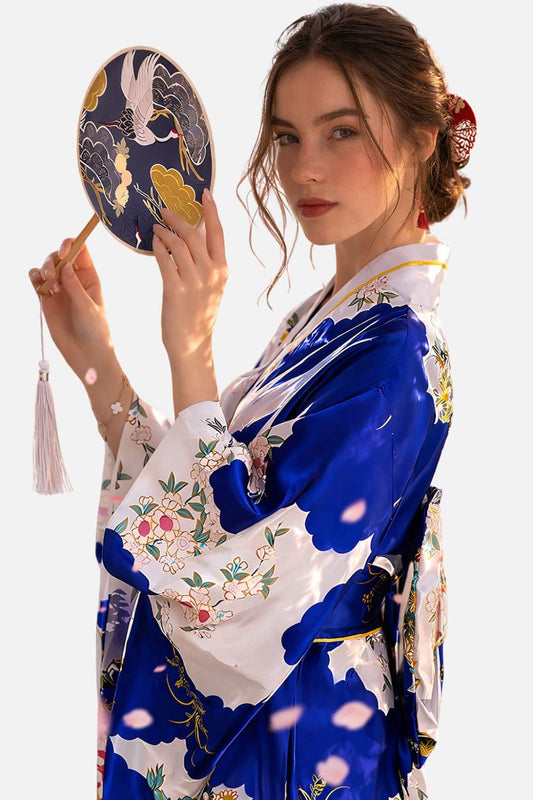 Femme en kimono satin bleu et blanc, tenant un éventail, avec des motifs floraux et une posture élégante