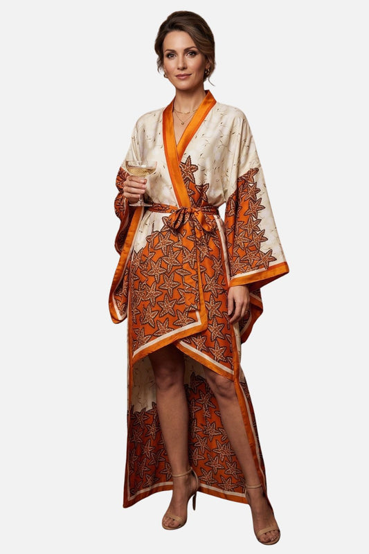 Femme en kimono satin aux motifs de feuilles orange, tenant un verre, sur fond neutre