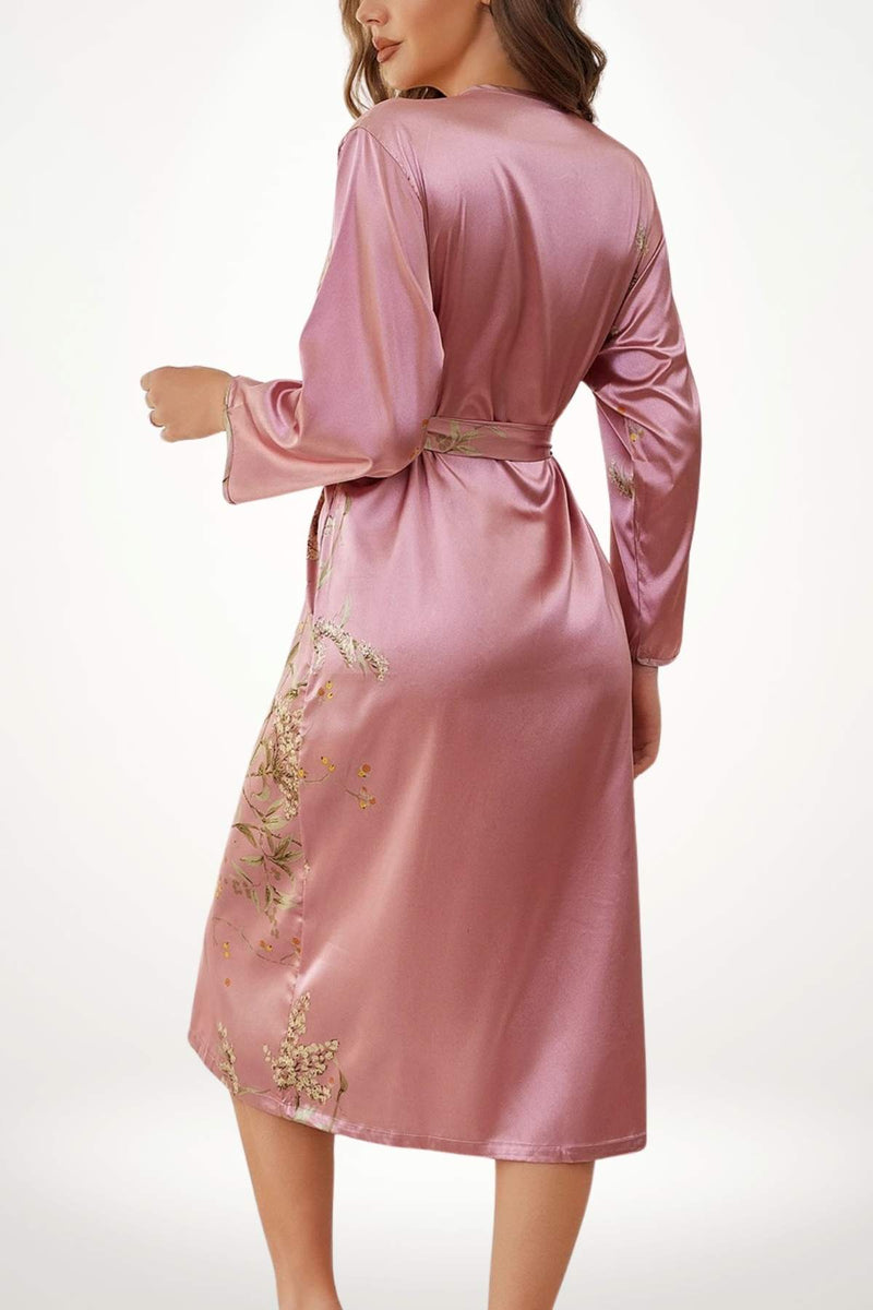 Kimono en satin rose avec des broderies florales, manches longues et ceinture à la taille, sur fond neutre