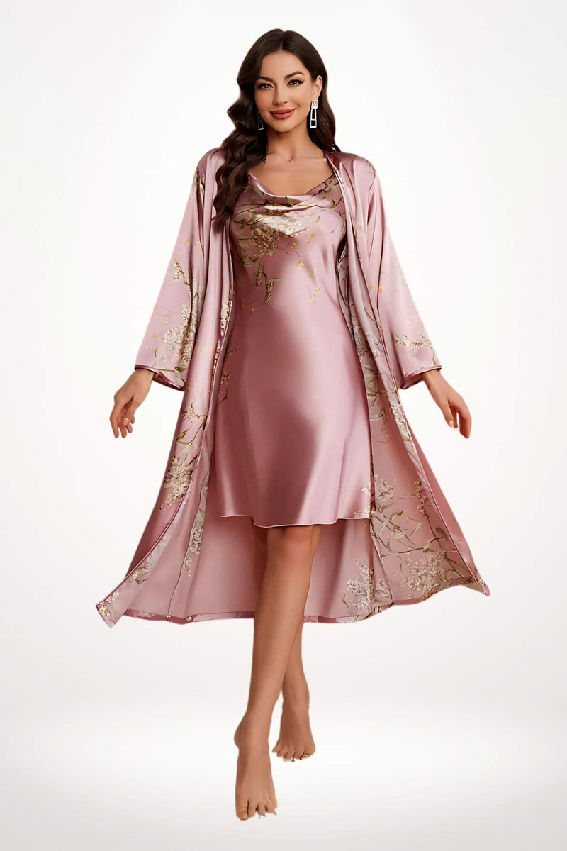 Femme en kimono rose satin avec motifs floraux, posant élégamment, pieds nus sur un fond neutre