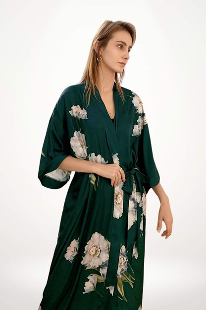 Kimono vert en satin avec des motifs floraux, porté par une femme dans un décor minimaliste