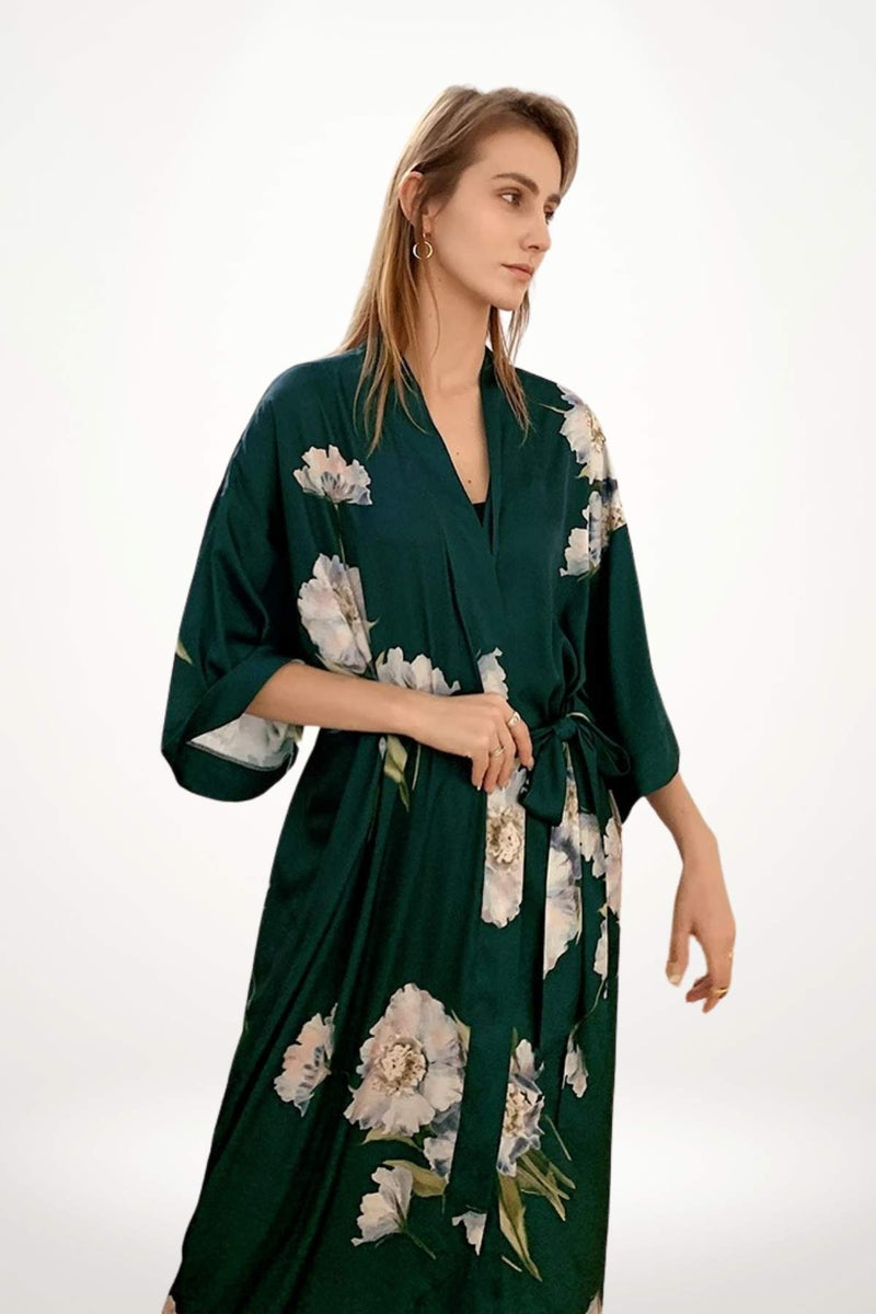 Kimono vert en satin avec des motifs floraux, porté par une femme dans un décor minimaliste