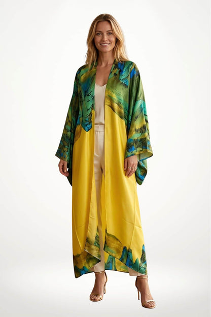 Femme souriante portant un long kimono aux motifs verts et jaunes, avec un fond blanc minimaliste