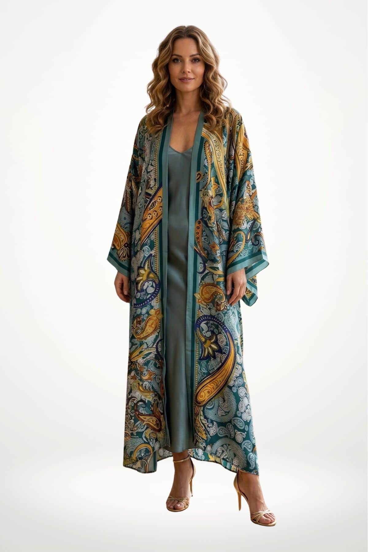 Femme portant un long kimono en satin aux motifs colorés, avec des tons verts, dorés et bleu, sur un fond