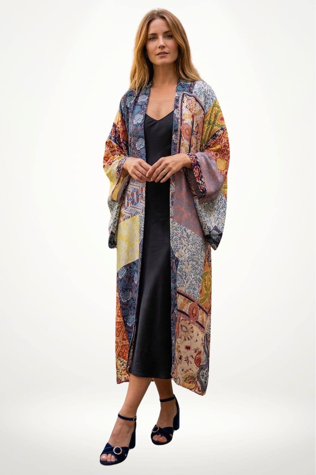 Femme portant un long kimono coloré aux motifs variés, avec une robe noire et des sandales à talons