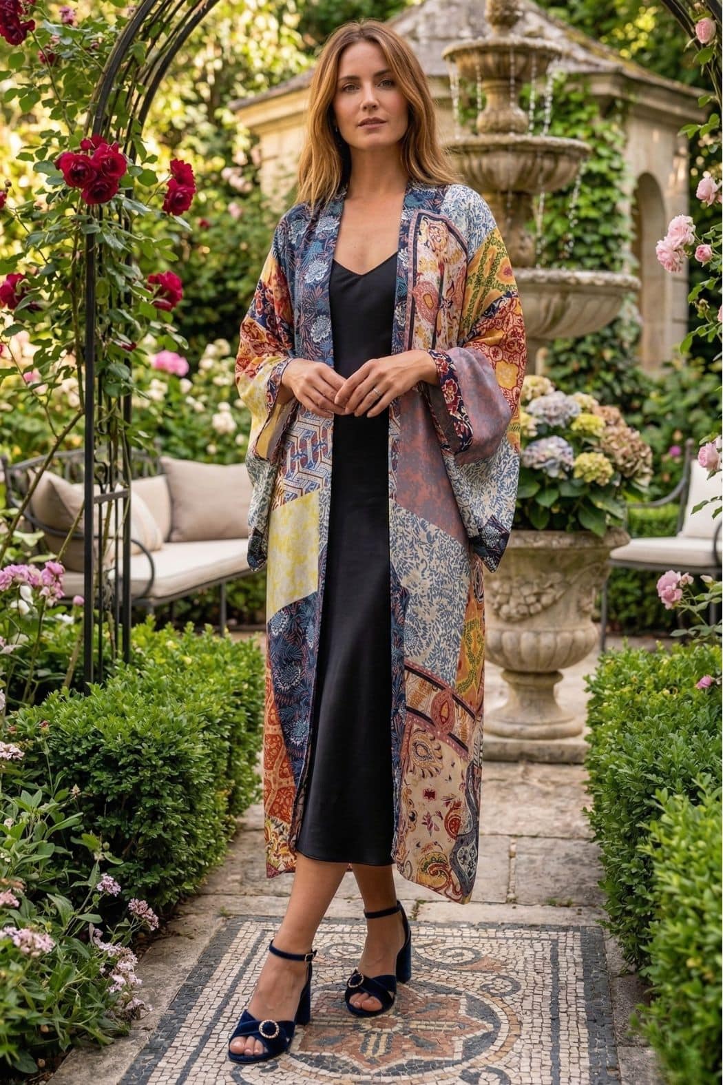 Femme en kimono coloré, posé dans un jardin fleuri, avec des roses et des hortensias en arrière-plan