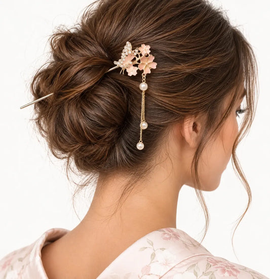 Chignon brun orné d’une épingle à petites fleurs roses et perles pendantes.