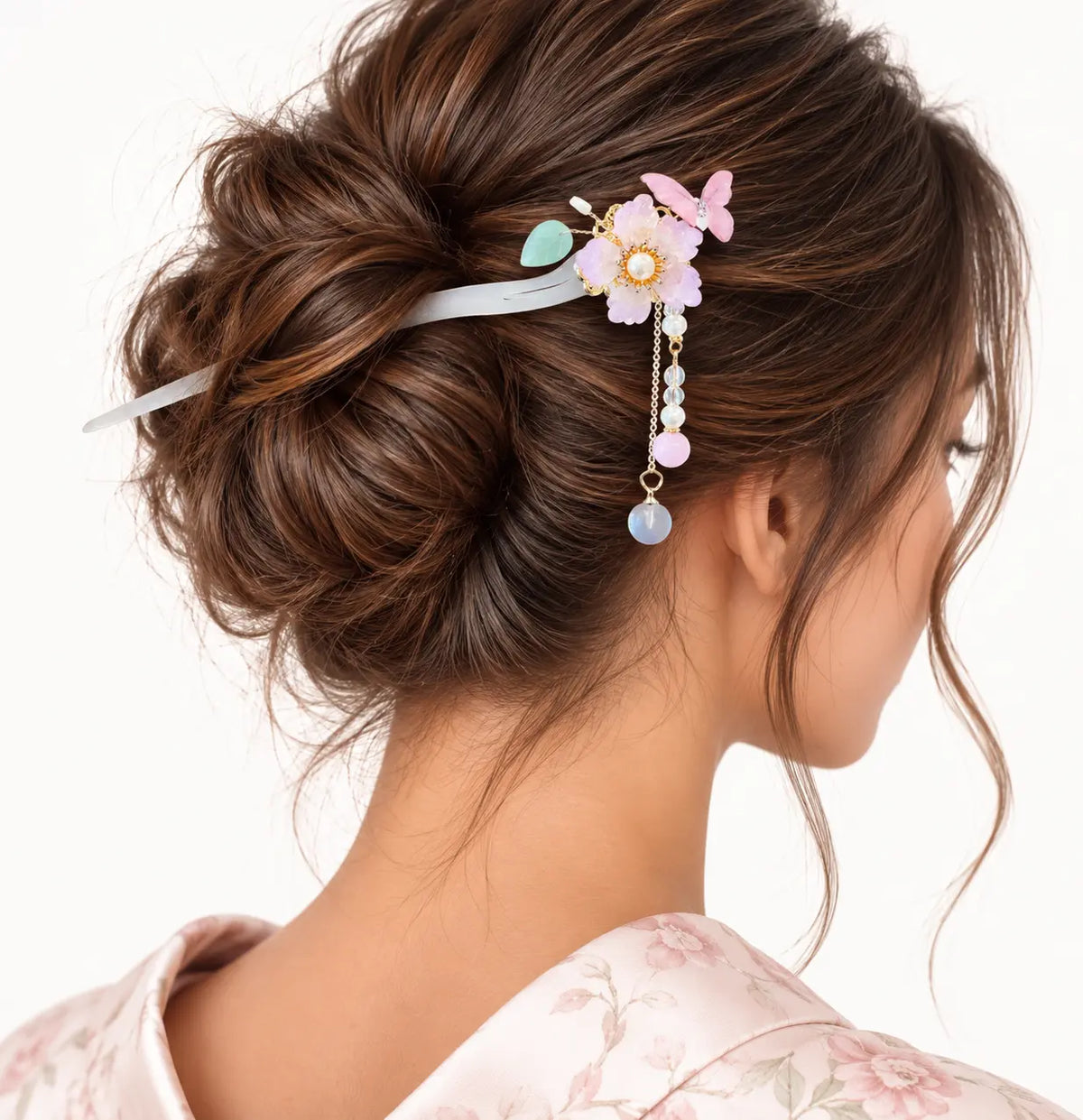 Chignon orné d’un bijou à fleur pâle et papillon pastel.
