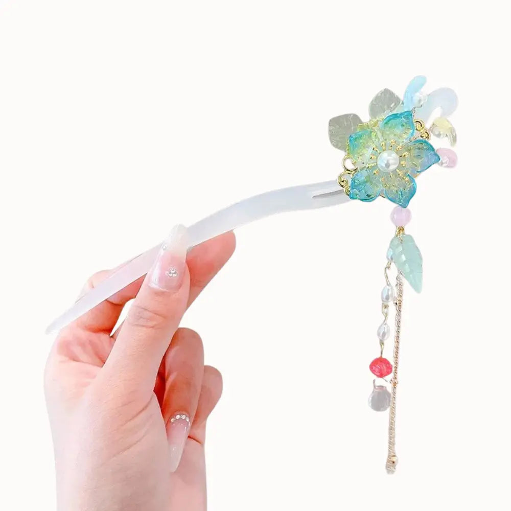 Bijou de cheveux orné d’une fleur irisée et de perles pastel.