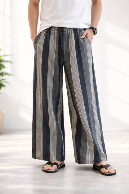 Pantalon hakama rayé en tissu léger, aux couleurs bleu et beige, porté avec un t-shirt blanc et des sandales