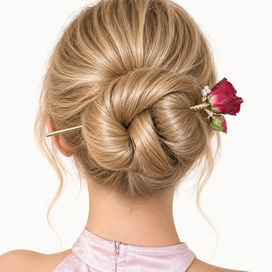 Chignon agrémenté d’un peigne à rose et fils dorés.