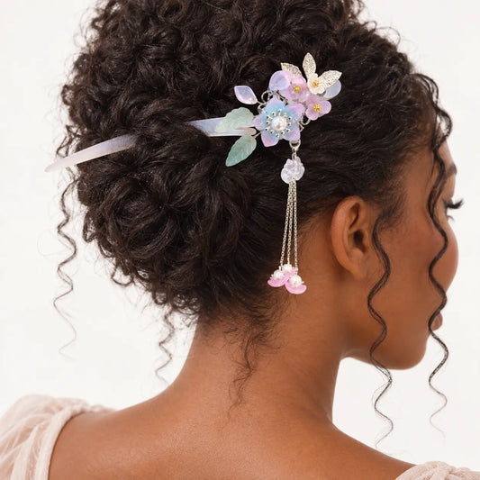 Chignon décoré d’un peigne à fleurs pastel et pendants roses.