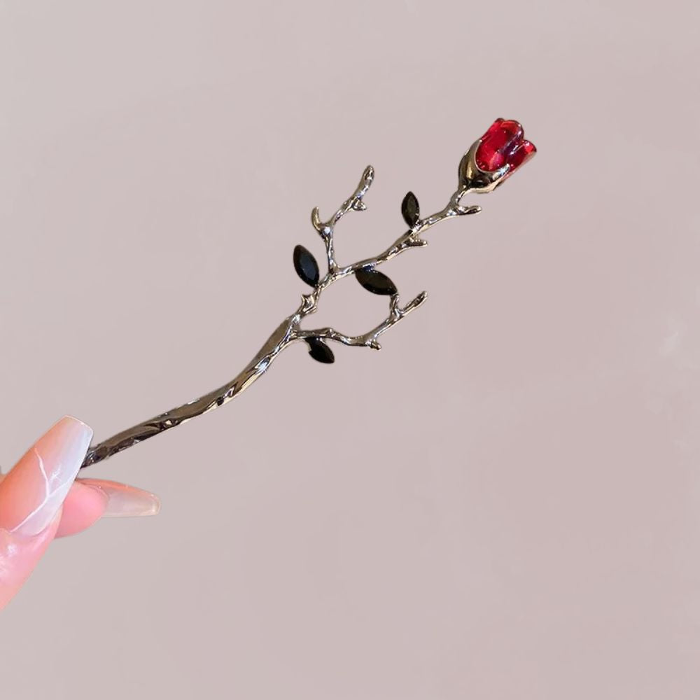 Accessoire cheveux en forme de branche avec une rose rouge, tige en ébène et feuilles noires
