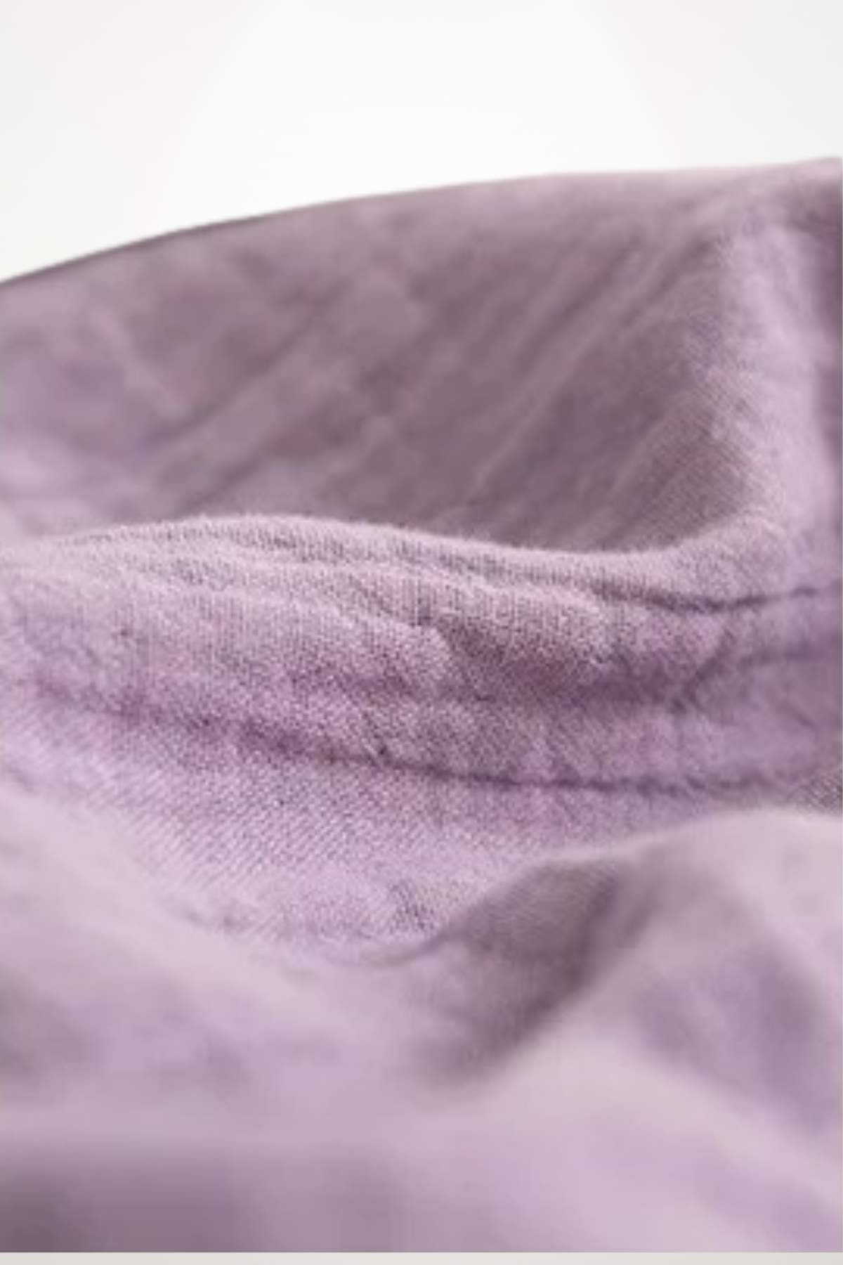 Tissu en coton doux de couleur lilas, présentant des plis délicats et une texture légère