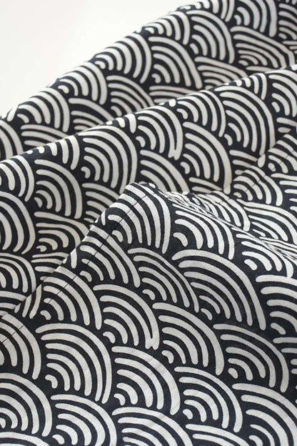 Tissu en coton noir avec motifs ondulés blancs, créant un effet élégant et moderne pour un peignoir kimono