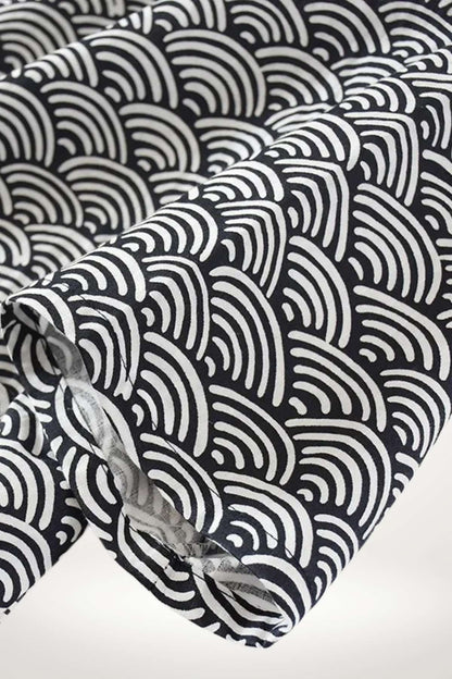 Peignoir kimono en coton noir avec motifs ondulés blancs, offrant une texture douce et un style élégant