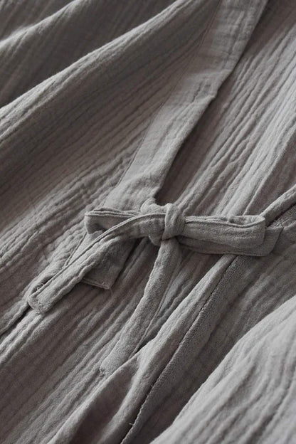 Peignoir kimono en tissu léger gris, avec un motif texturé et une ceinture nouée à l'avant