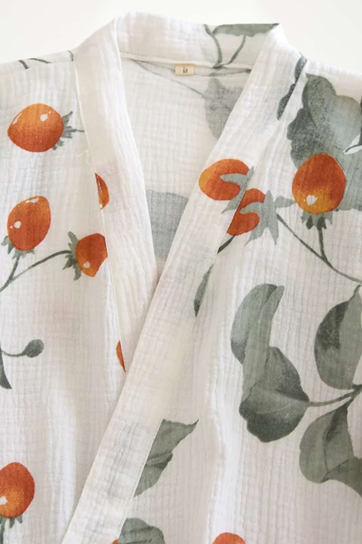 Kimono en coton léger avec motifs de cerises orange et feuillage vert sur fond blanc