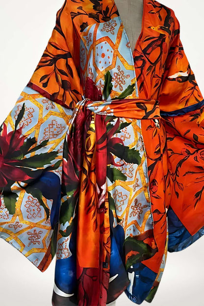 Robe kimono aux couleurs vives orange et bleue, ornée de motifs floraux et géométriques, drapée élégamment