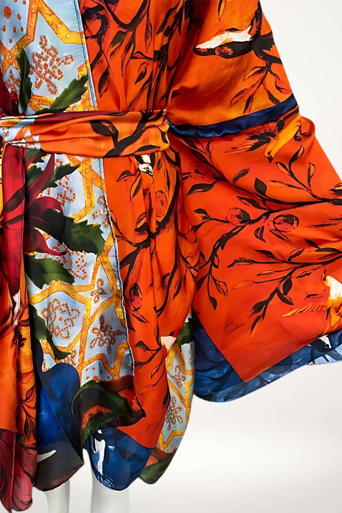 Robe kimono en satin orange vif ornée de motifs floraux, avec des détails bleus et dorés, drapée élégamment
