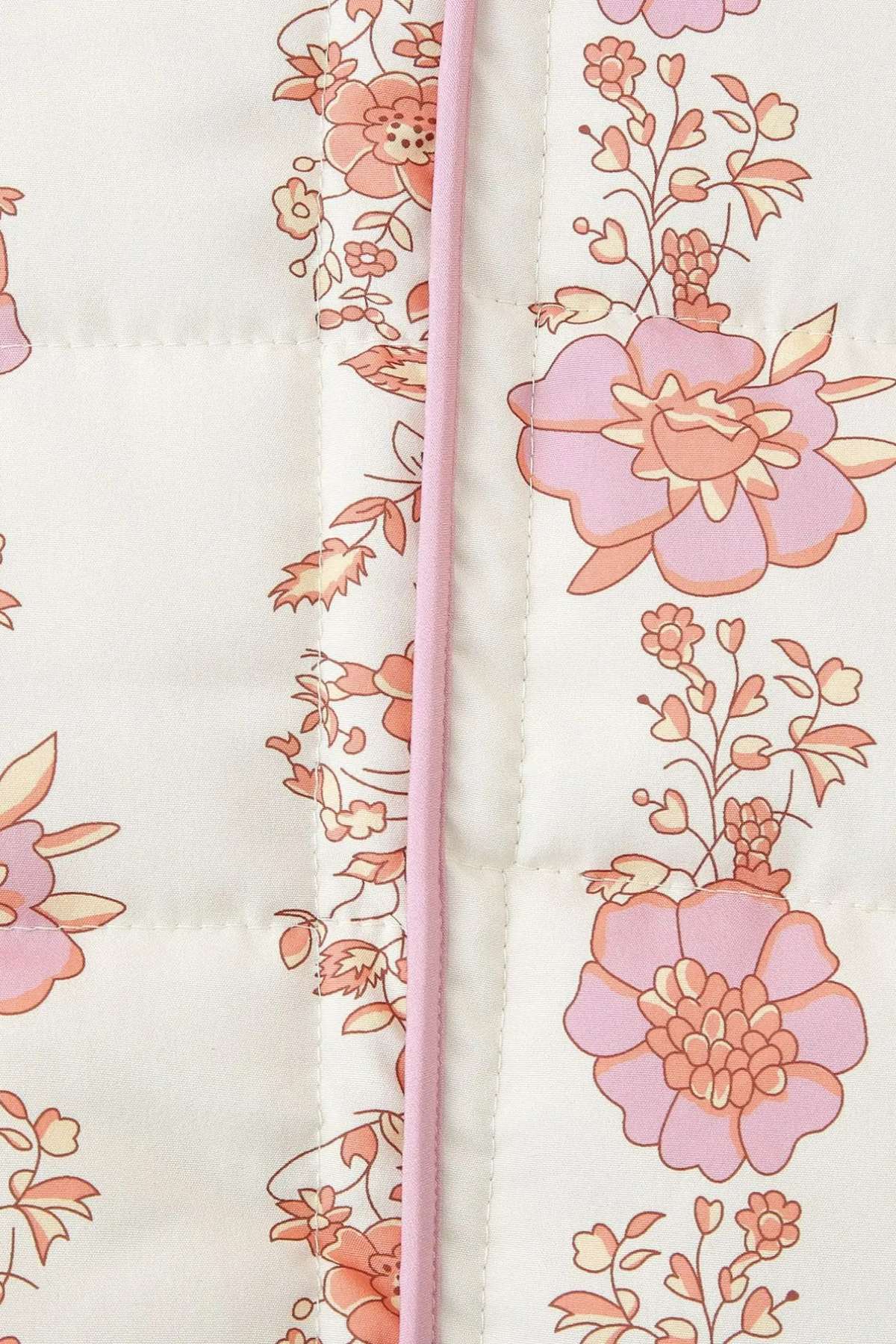 Gros plan sur le tissu matelassé et les motifs de pivoines roses de la veste kimono Kimoky