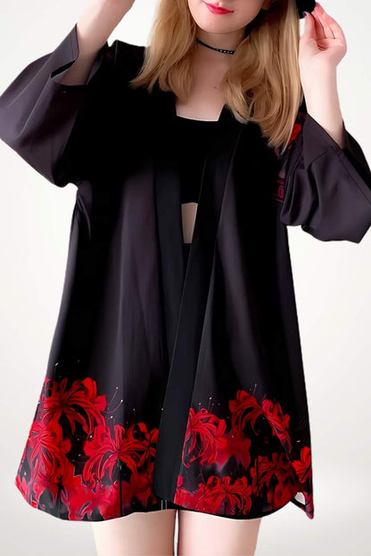 Veste kimono femme noire ornée de motifs floraux rouges, portée avec une posture décontractée sur fond clair
