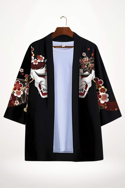 Veste kimono noire ornée de motifs floraux et de masques, avec un intérieur bleu clair, suspendue sur un cintre