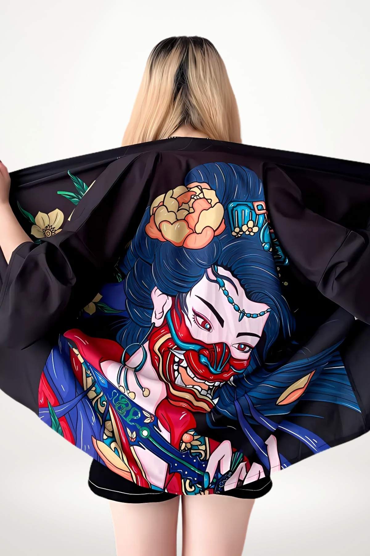 Veste kimono noire avec un motif coloré représentant un visage masqué et des fleurs, portée par une femme de dos