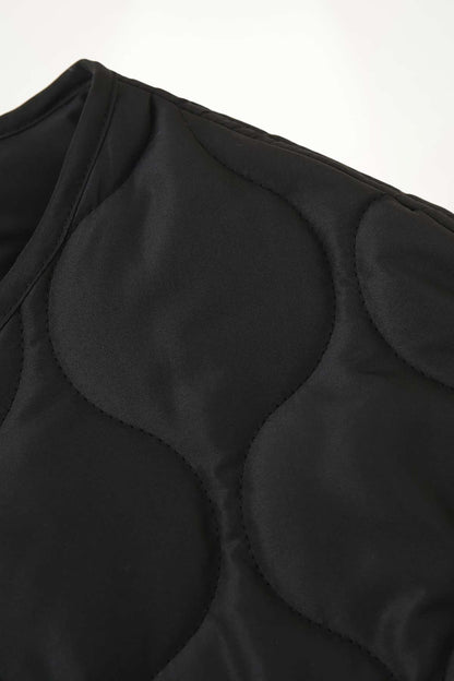 Veste kimono femme matelassée noire en polyester avec quilting circulaire, coupe droite et col rond.