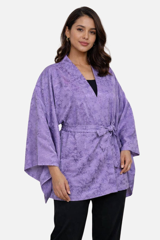 Veste kimono femme en tissu violet avec motifs floraux subtils, portée avec élégance et ceinture nouée