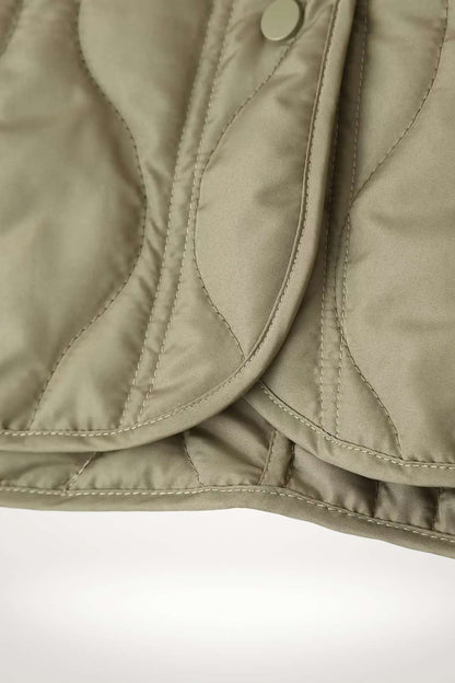 Veste kimono matelassée hiver kaki en polyester avec matelassage ondulé et bouton-pressions ton sur ton.