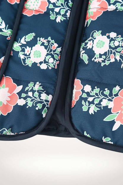 Gros plan sur l'imprimé floral corail et vert de la veste kimono matelassée sur le bas de la veste
