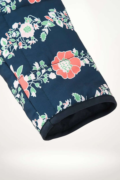 Gros plan sur l'imprimé floral corail et vert de la veste kimono matelassée sur la manche
