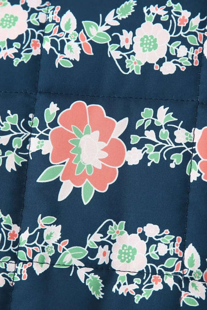 Gros plan sur l'imprimé floral corail et vert de la veste kimono matelassée